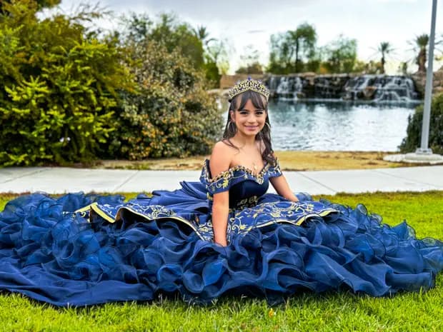Outdoor quinceanera portrait with a clean scenic background.