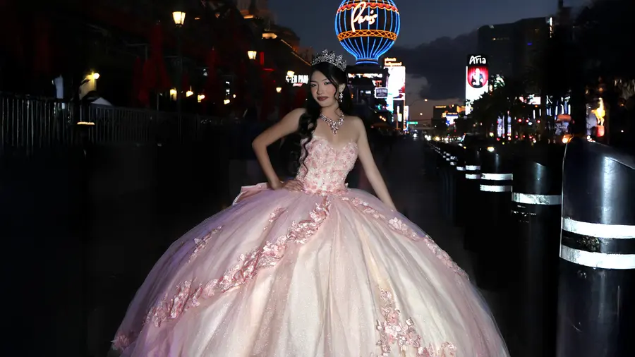 Quinceanera portrait framed by Las Vegas evening lights.